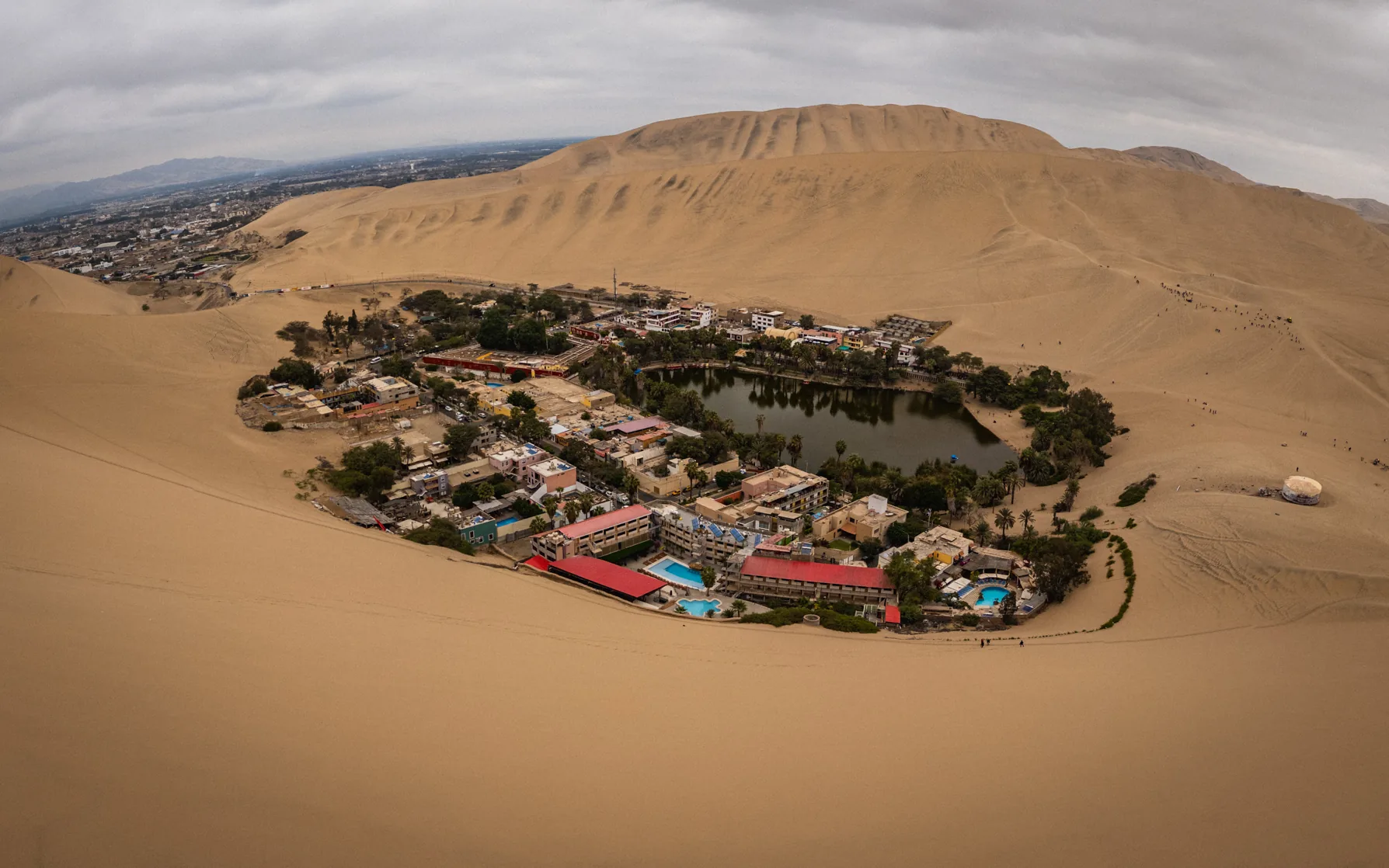 The Huacachina oasis surrounded by sweeping desert dunes