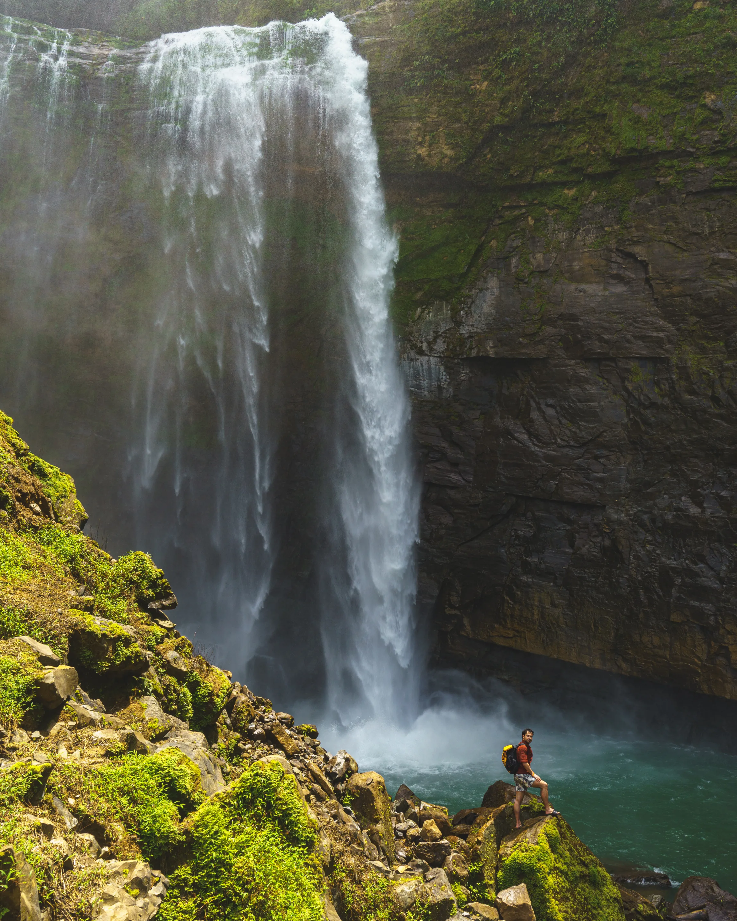 A tall waterfall surrounded by dense vegetation in Costa Rica